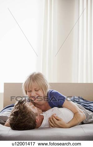 Woman lying atop man in bed View Large Photo Image Stock Photo - Woman lying atop man in bed. Fotosearch