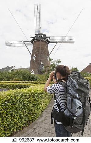 Woman photographing windmill View Large Photo Image Stock Photo - Woman photographing windmill. Fotosearch