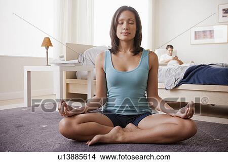 Picture - Woman practicing yoga in bedroom. Fotosearch