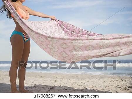 Woman preparing blanket on beach View Large Photo Image Stock Photo - Woman preparing blanket on beach. Fotosearch