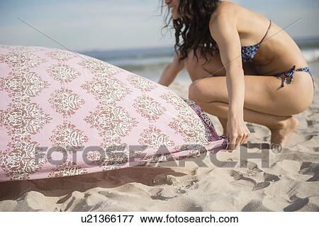 Woman preparing blanket on beach View Large Photo Image Stock Photo - Woman preparing blanket on beach. Fotosearch