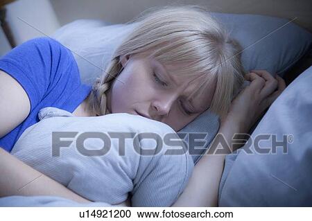 Stock Image - Woman sleeping on bed. Fotosearch
