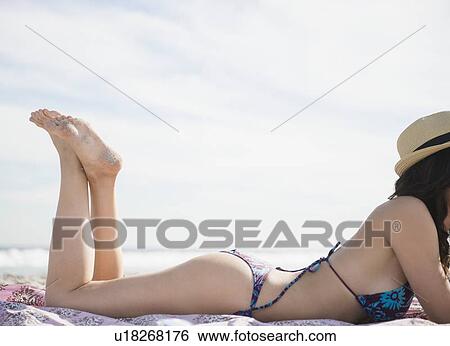 Stock Photograph - Woman sunbathing on beach. Fotosearch