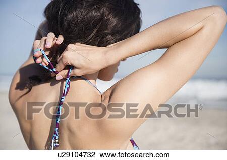 Woman tying bikini top View Large Photo Image Stock Image - Woman tying bikini top. Fotosearch