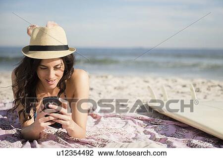 Woman using cell phone on beach View Large Photo Image Stock Image - Woman using cell phone on beach. Fotosearch