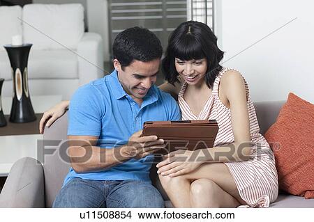 Picture - Young couple looking at photos. Fotosearch