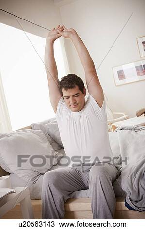 Young man stretching after waking up View Large Photo Image Stock Image - Young man stretching after waking up. Fotosearch