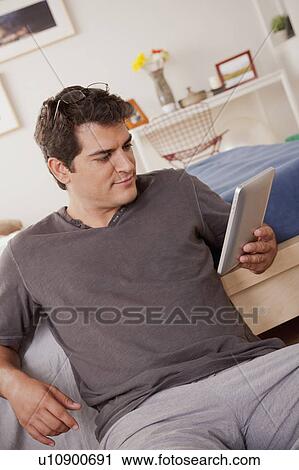 Stock Image - Young man using digital tablet. Fotosearch