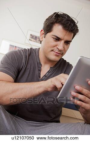 Young man using digital tablet View Large Photo Image Stock Image - Young man using digital tablet. Fotosearch