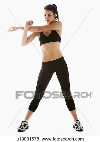 Stock Photo - Young woman stretching, studio shot. Fotosearch