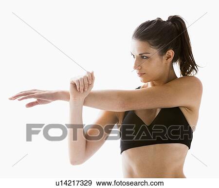 Young woman stretching, studio shot View Large Photo Image Stock Photo - Young woman stretching, studio shot. Fotosearch