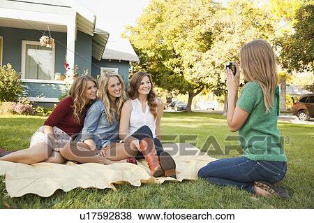 Young woman taking picture of her friends View Large Photo Image Stock Photo - Young woman taking picture of her friends. Fotosearch