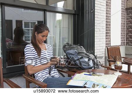 Stock Image - Young woman with backpack and camera. Fotosearch