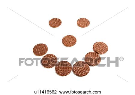 Stock Image - Biscuits arranged in shape of smiley face over white background. Fotosearch
