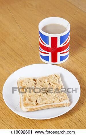 Stock Image - British coffee mug and slice of bread with butter on table. Fotosearch