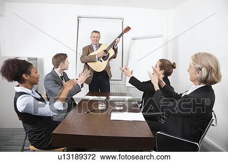 Businessman playing guitar in business meeting View Large Photo Image Stock Image - Businessman playing guitar in business meeting. Fotosearch
