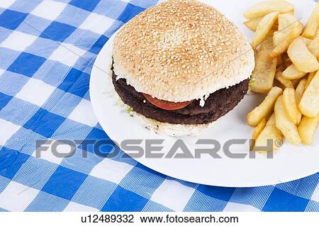 Close-up of hamburger and French fries on table View Large Photo Image Stock Image - Close-up of hamburger and French fries on table. Fotosearch
