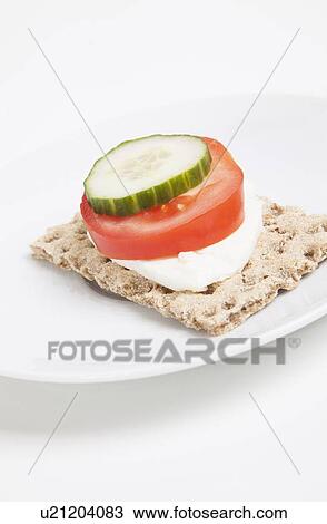 Stock Image - Crispbread with tomato and cucumber slice and cheese. Fotosearch