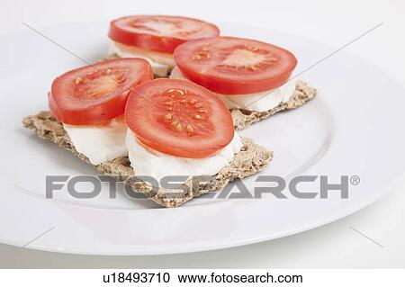 Stock Image - Crispbreads with tomato slices and cheese. Fotosearch