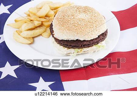 Stock Photograph - Cropped shot of chips and burger over America flag. Fotosearch
