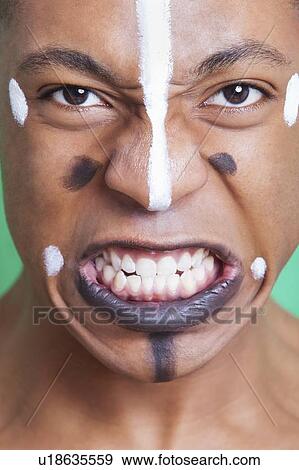 Detail shot of aggressive mixed race man with painted face clenching teeth View Large Photo Image Stock Photo - Detail shot of aggressive mixed race man with painted face clenching teeth. Fotosearch