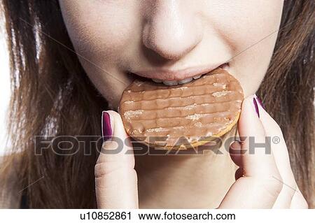Detail shot of young woman eating cookie View Large Photo Image Stock Image - Detail shot of young woman eating cookie. Fotosearch