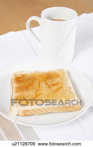 Stock Photo - Jam on slice of bread with cup of coffee. Fotosearch