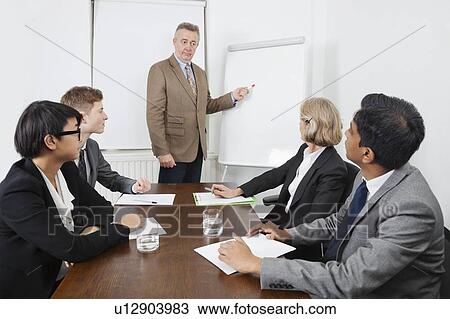 Man using whiteboard in business meeting View Large Photo Image Stock Image - Man using whiteboard in business meeting. Fotosearch