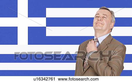Middle-aged businessman adjusting necktie with pride over Greek flag View Large Photo Image Stock Image - Middle-aged businessman adjusting necktie with pride over Greek flag. Fotosearch