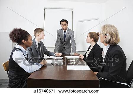 Stock Image - Multiethnic businesspeople at meeting in conference room. Fotosearch