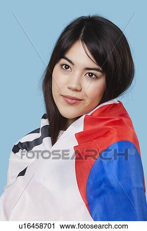 Patriotic young woman wrapped in Korean flag over blue background View Large Photo Image Stock Image - Patriotic young woman wrapped in Korean flag over blue background. Fotosearch