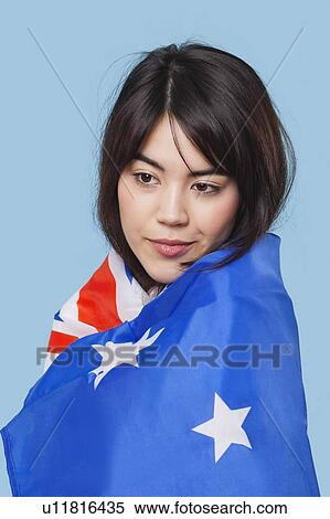 Patriotic young woman wrapped in Australian flag over blue background View Large Photo Image Stock Photography - Patriotic young woman wrapped in Australian flag over blue background. Fotosearch
