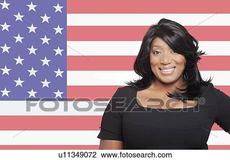 Stock Image - Portrait of casual mixed race woman against American flag. Fotosearch