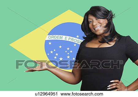 Portrait of casual mixed race woman holding out empty palm over Brazilian flag View Large Photo Image Stock Image - Portrait of casual mixed race woman holding out empty palm over Brazilian flag. Fotosearch