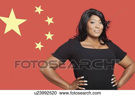 Stock Image - Portrait of casual mixed race woman against Chinese flag. Fotosearch