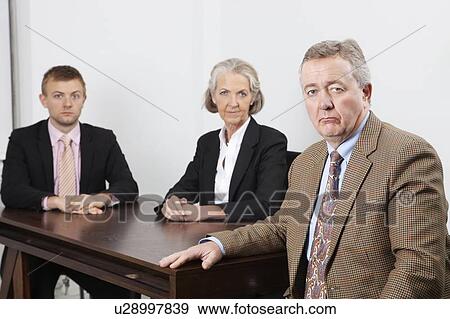 Portrait of confident business group at desk in office View Large Photo Image Stock Photo - Portrait of confident business group at desk in office. Fotosearch