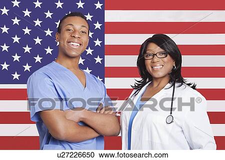 Portrait of confident mixed race male and female surgeons over American flag View Large Photo Image Stock Image - Portrait of confident mixed race male and female surgeons over American flag. Fotosearch