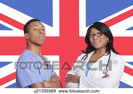 Stock Photo - Portrait of confident mixed race male and female surgeons over British flag. Fotosearch