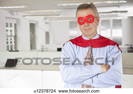 Portrait of serious businessman in superhero costume in office View Large Photo Image Picture - Portrait of serious businessman in superhero costume in office. Fotosearch