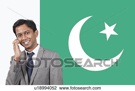 Stock Image - Portrait of young businessman using cell phone over Pakistani flag. Fotosearch