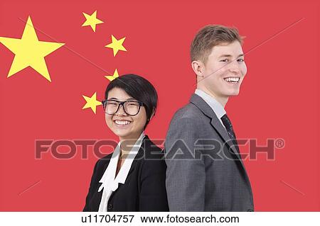 Stock Photo - Portrait of young businesswoman and man smiling over Chinese flag. Fotosearch