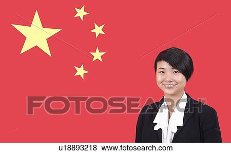 Stock Photo - Portrait of young businesswoman smiling over Chinese flag. Fotosearch