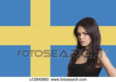 Stock Photography - Portrait of young woman against Swedish flag. Fotosearch