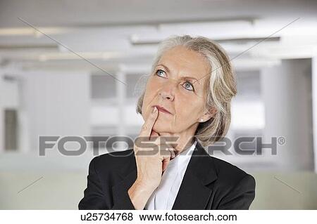 Thoughtful senior businesswoman looking up in office View Large Photo Image Stock Photo - Thoughtful senior businesswoman looking up in office. Fotosearch