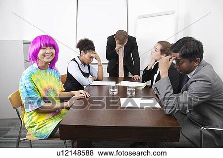 Tired multiethnic businesspeople with colleague in pink wig at meeting View Large Photo Image Stock Photo - Tired multiethnic businesspeople with colleague in pink wig at meeting. Fotosearch