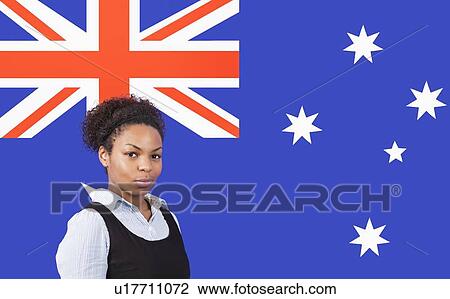 Stock Image - Young African American businesswoman smiling over Australian flag. Fotosearch