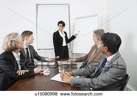 Stock Photo - Young woman using whiteboard in business meeting. Fotosearch