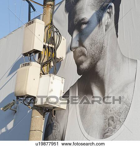 Stock Image - Close-up of a telephone pole in front if a billboard, Tophane, Istanbul, Turkey. Fotosearch