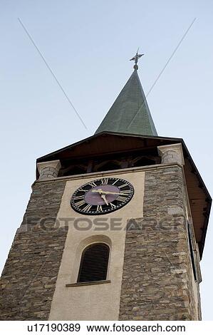 Stock Photo - Low angle view of the clock tower of a church, Zermatt, Valais Canton, Switzerland. Fotosearch