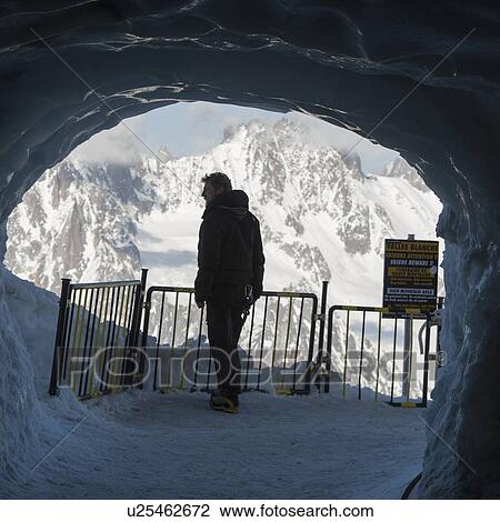 Man standing in snow cave and looking at snow covered mountains, Aiguille Du Midi, Mont Blanc, Chamonix, Rhone-Alpes, France View Large Photo Image Stock Image - Man standing in snow cave and looking at snow covered mountains, Aiguille Du Midi, Mont Blanc, Chamonix, Rhone-Alpes, France. Fotosearch